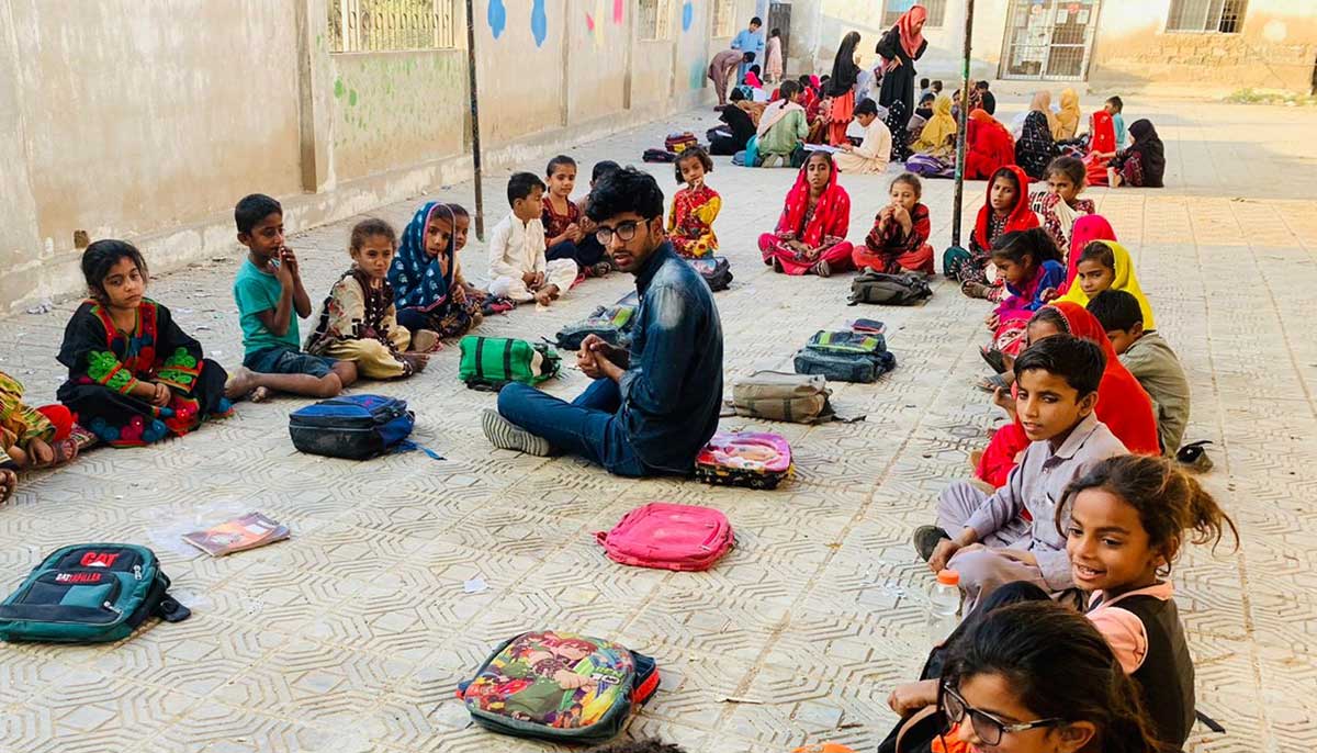 Sufiyan Ahmad seated in the centre of his open classroom with his students gathered around him. — Photo by Sufiyan Ahmad