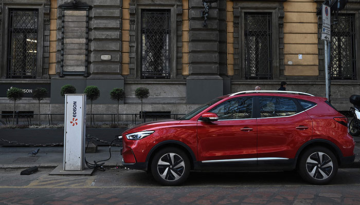 (FILES) In this file photo taken on March 23, 2023, an MG electric SUV charges at a hub in downtown Milan. The 27 EU member states approved Monday a deal between Brussels and Germany that lifted Berlin´s block on a planned phaseout of new sales of fossil fuel cars by 2035.—AFP