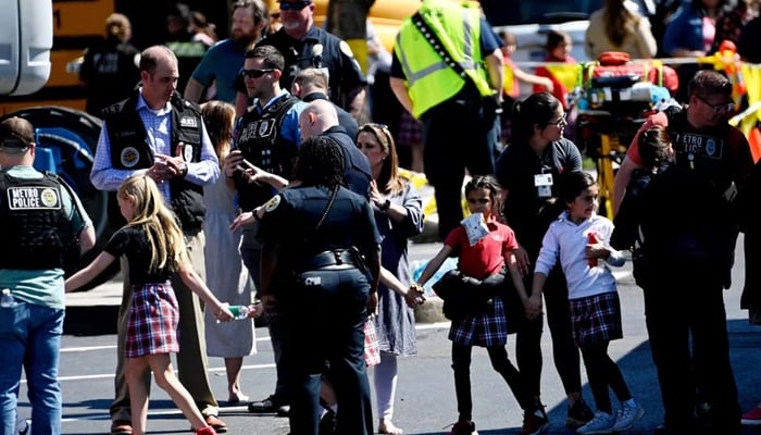 Students from the Covenant School hold hands after getting off a bus to meet their parents at the reunification site following a mass shooting at the school in Nashville, Tennessee, US on March 27, 2023. — Reuters