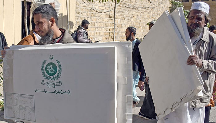 14 جنوری 2023 کو کراچی میں بلدیاتی انتخابات کے موقع پر لوگ انتخابی مواد لے کر جا رہے ہیں۔ — آن لائن