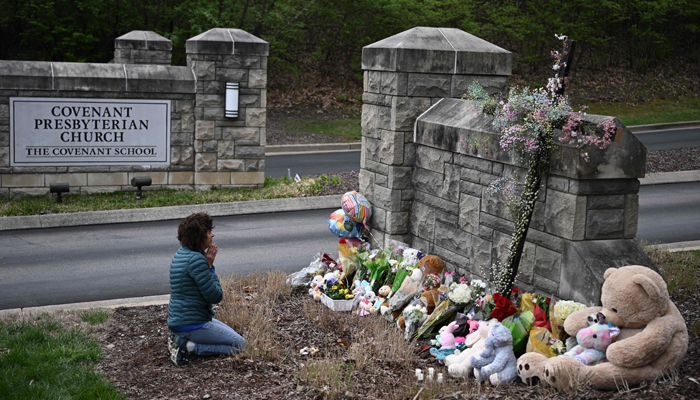 A person at a makeshift memorial for victims outside the Covenant School building at the Covenant Presbyterian Church following a shooting, in Nashville, Tennessee, on March 28, 2023. — AFP