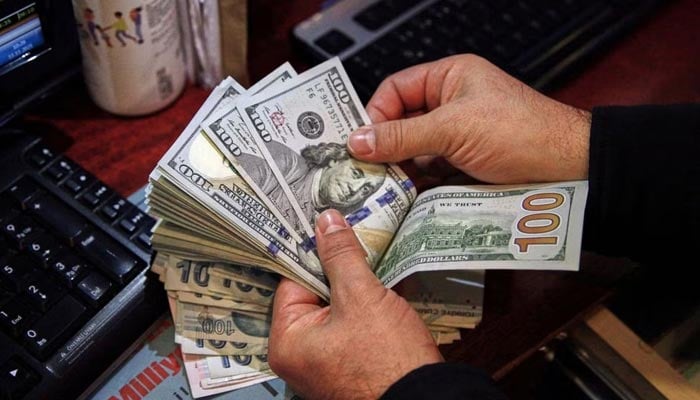 A money changer counts US dollar banknotes at a currency exchange office in Ankara, Turkey November 11, 2021. — Reuters