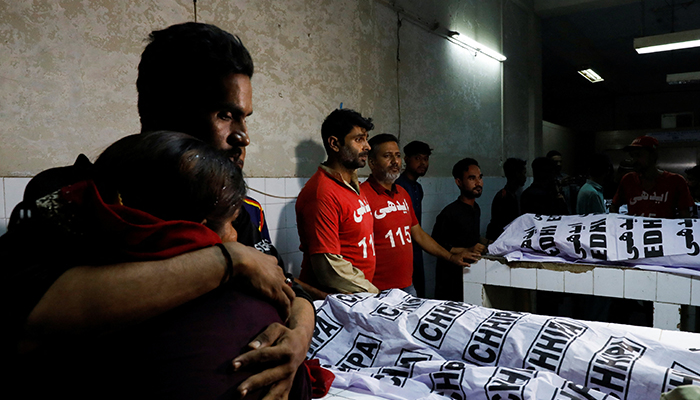 People mourn the death of a relative, who was killed along with others in a stampede during a handout distribution, at a hospital morgue in Karachi, on March 31, 2023. — Reuters