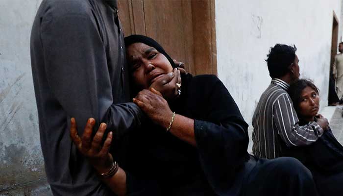 People mourn the death of a relative, who was killed with others in a stampede during handout distribution, at a hospital morgue in Karachi, on March 31, 2023. — Reuters