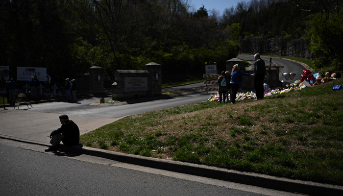 People pay their respects at a makeshift memorial for victims at the Covenant School building at the Covenant Presbyterian Church following a shooting, in Nashville, Tennessee, on March 28, 2023. — AFP