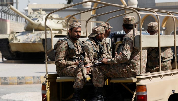 Army soldiers in a vehicle drive past a war monument, at the entrance of Malir Garrison in Karachi on February 7, 2023. — Reuters