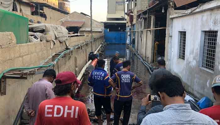 Rescue workers stand at the incidents site in Karachis SITE Area on March 31, 2023. — Geo.tv