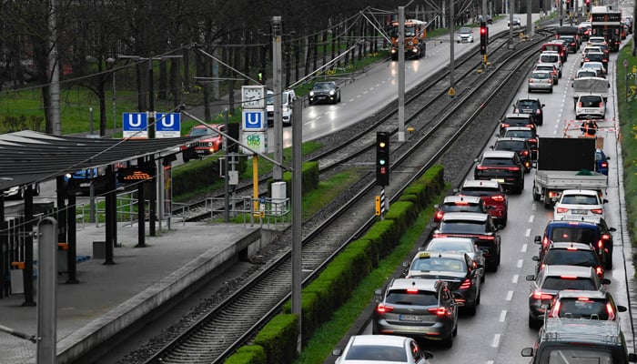 Cars stand in a traffic jam towards the city centre next to an empty commuter train station in Stuttgart, southern Germany on March 27, 2023. — AFP