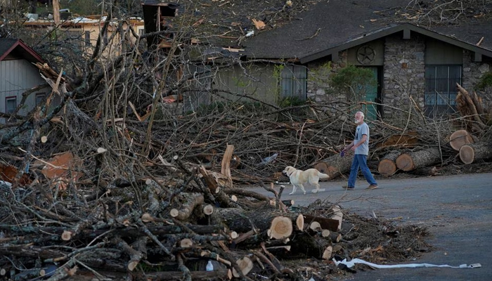 A man walks a dog through a neighbourhood severely damaged in the aftermath of a tornado, after a monster storm system tore through the South and Midwest on Friday in Little Rock, Arkansas, US April 1, 2023. — Reuters