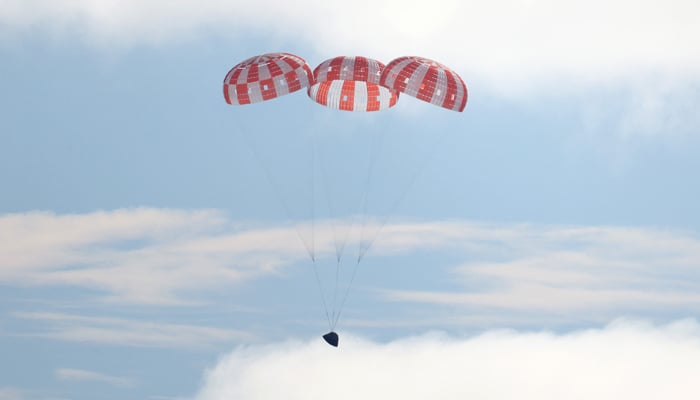 NASAs Orion Capsule descends toward splash down after a successful uncrewed Artemis I Moon Mission on December 11, 2022, seen from aboard the USS Portland in the Pacific Ocean off the coast of Baja California, Mexico. — AFP