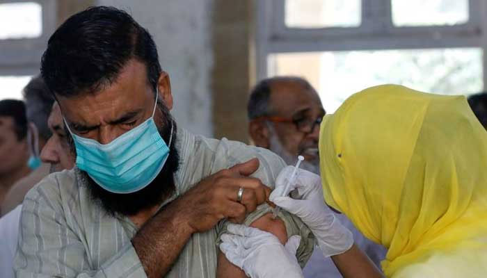 28 اپریل 2021 کو کراچی کے ایک ویکسینیشن سینٹر میں ایک شخص کو کورونا وائرس کی بیماری (COVID-19) کی ویکسین کی خوراک مل رہی ہے۔ - رائٹرز