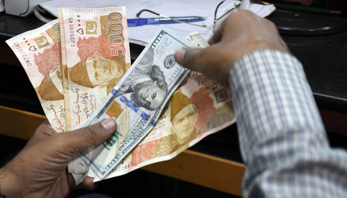 A foreign currency dealer counts US dollars at a shop in Karachi on March 02, 2023. — Online