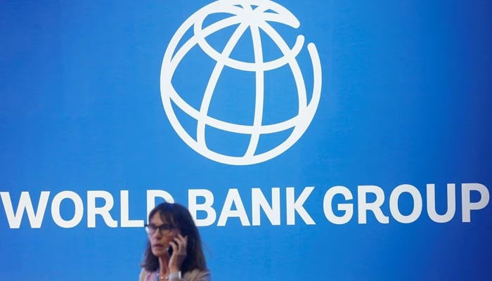 A participant stands near a logo of World Bank at the International Monetary Fund - World Bank Annual Meeting 2018 in Nusa Dua, Bali, Indonesia, October 12, 2018. — Reuters