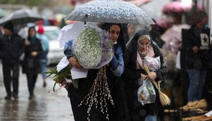Iranian women walk through the rain in a flower market, ahead of Nowruz, the Iranian New Year, in Tehran, Iran March 16, 2023. —Reuters