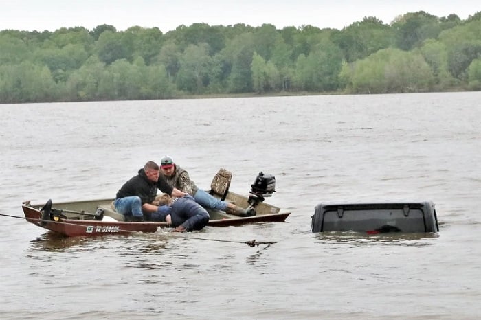 Two men rescue a woman from a submerged Jeep on the south side of Lake o’ the Pines in southwest Marion County, Texas, on Friday.— Marion County Sheriffs Office via Facebook