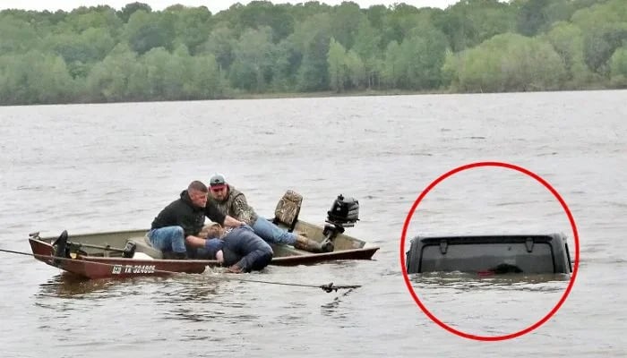 Two men rescue a woman from a submerged Jeep on the south side of Lake o’ the Pines in southwest Marion County, Texas, on Friday.— Marion County Sheriffs Office via Facebook