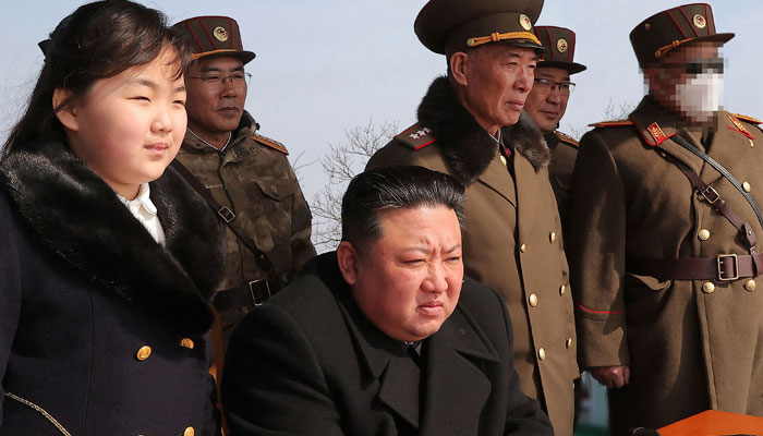 This picture shows North Koreas leader Kim Jong Un (C) and his daughter (L) observing a warhead missile launch exercise simulating a tactical nuclear attack in Cheolsan County, North Pyongan Province on MArch 20, 2023. — AFP