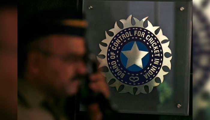 A policeman walks past a logo of the Board of Control for Cricket in India (BCCI). — Reuters/File