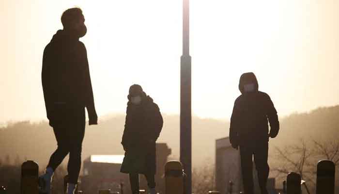 People wearing masks to prevent contracting the coronavirus disease (COVID-19) take a walk on a cold winter day at a Han river park in Seoul, South Korea, January 13, 2022. — Reuters