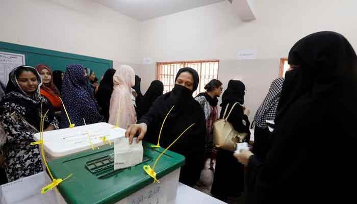 A woman casts her ballot while other wait for their turn at a polling station during the general election in Karachi, Pakistan, July 25, 2018. — Reuters