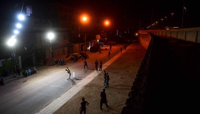 People play cricket during a nighttime cricket tournament during the month of Ramadan in Karachi on April 11, 2023. — AFP