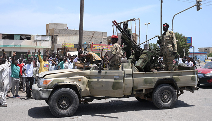 سوڈانی 16 اپریل 2023 کو بحیرہ احمر کے شہر پورٹ سوڈان میں آرمی چیف عبدالفتاح البرہان کے وفادار فوجی جوانوں کا استقبال کر رہے ہیں۔ — اے ایف پی