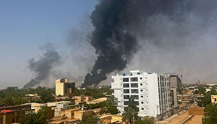 Smoke billows above residential buildings in Khartoum on April 16, 2023. — AFP