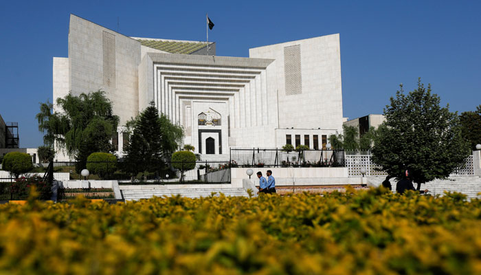 Two policemen walk past the Supreme Court building in Islamabad. — Reuters/File