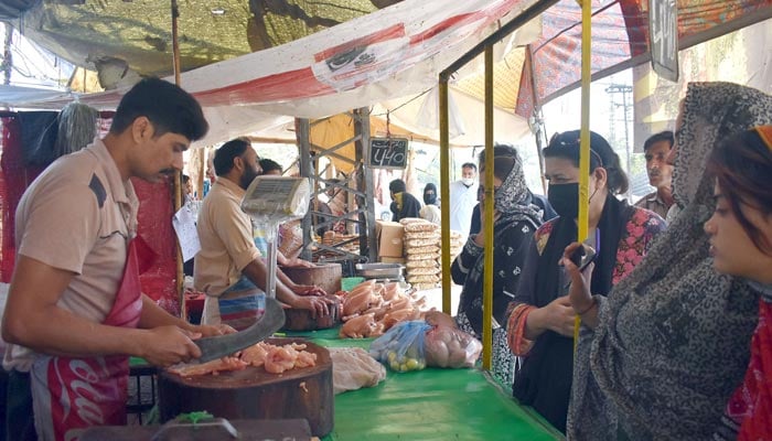 Women are buying chicken from stalls at the weekly Sunday Market in Lahore on April 2, 2023. — Online
