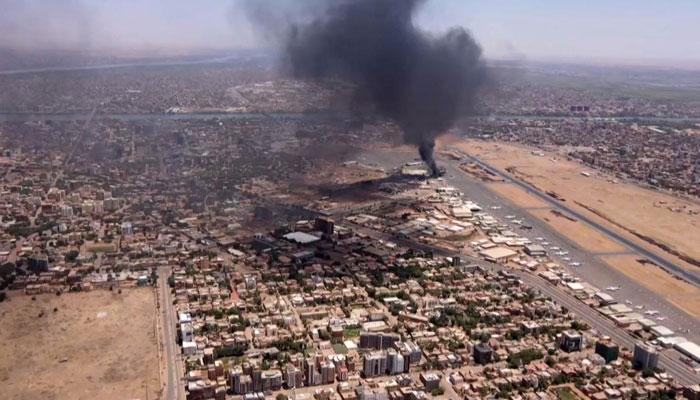 This image grab taken from AFPTV video footage on April 20, 2023, shows an aerial view of black smoke rising above the Khartoum International Airport. — AFP