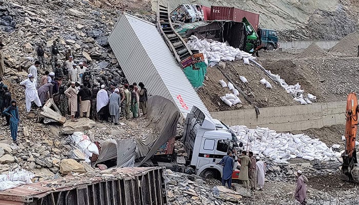 Security officials and onlookers gather near damaged trucks following a landslide near Torkham border on April 18, 2023. — AFP/File