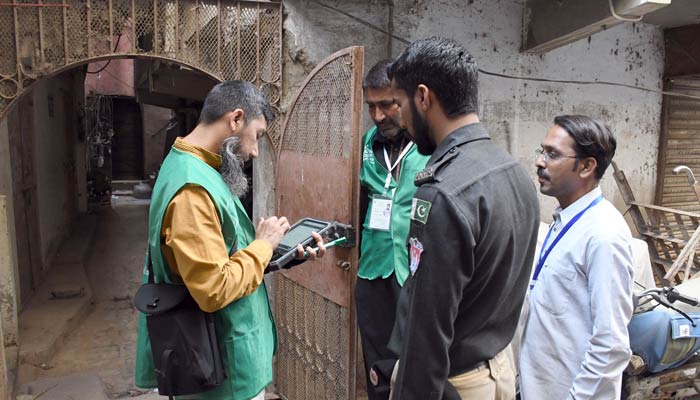 A Pakistan Bureau of Statistics official uses a digital device to collect information from a resident during door-to-door data collection at the first-ever digital national census in Karachi on March 28, 2023. — ONLINE