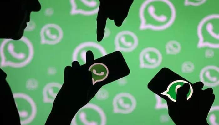 A representational image showing people holding phones with the WhatsApp logo on the screen. — Reuters/File