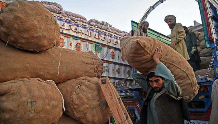 A Pakistani labourer carries a sack of potatoes at a fruit and vegetable market in Peshawar. AFP/File