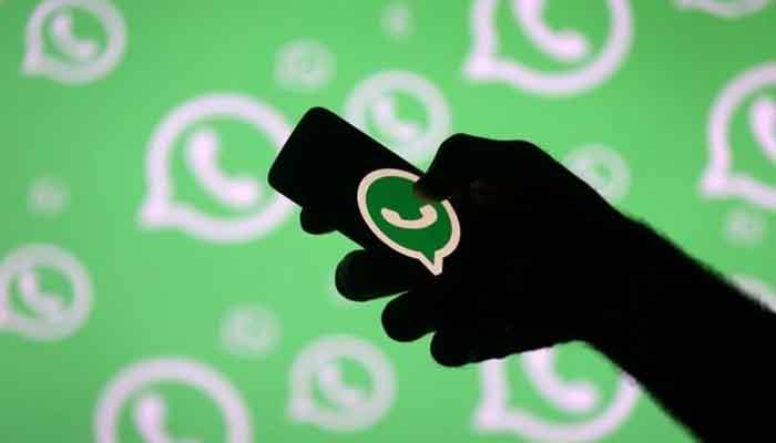 A man poses with a smartphone in front of displayed Whatsapp logo in this illustration September 14, 2017. — Reuters