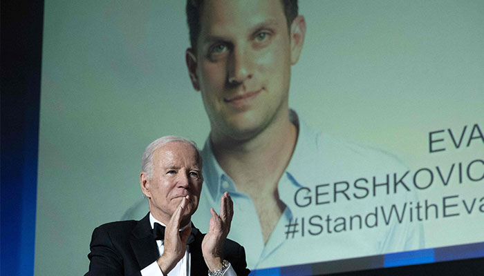 US President Joe Biden gestures as an image of US journalist Evan Gershkovich appears onscreen during the White House Correspondents´ Association dinner at the Washington Hilton in Washington, DC, April 29, 2023.—AFP