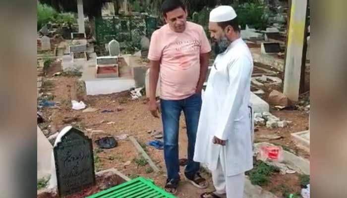 Social worker, who verified presence of padlocked grave in Indian city Hyderabad, which went viral last week with fake news linking it with Pakistan, stands with the Muazzin Muqtar in the graveyard, in this still taken from a video. — Alt News