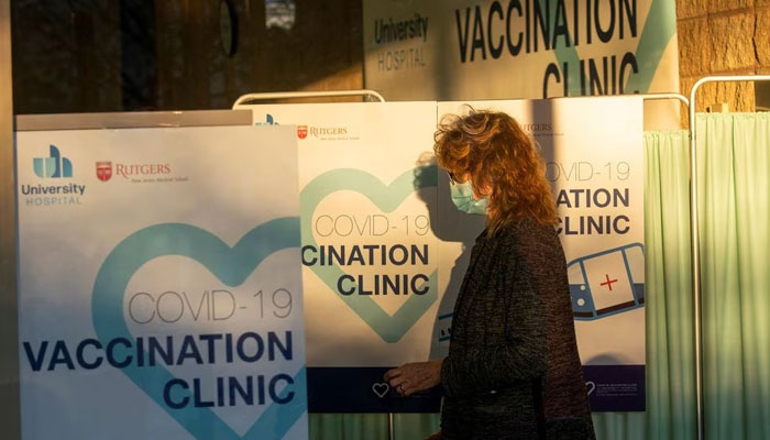 A health worker passes by the area where people get vaccine at University Hospitals COVID-19 vaccine clinic at Rutgers New Jersey Medical School in Newark, New Jersey, U.S., December 15, 2020.