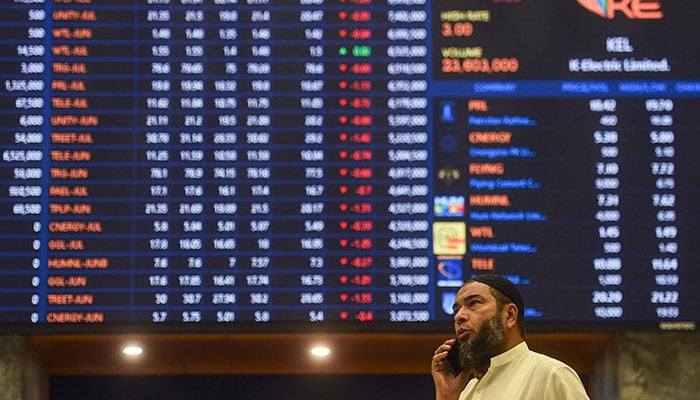 A stockbroker speaks on a phone while monitoring the share prices during a trading session at the Pakistan Stock Exchange (PSX) in Karachi on June 24, 2022. — AFP