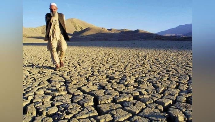 A man walks across dry, cracked land, which was previously lush and green, near Lake Hanna near Quetta, Pakistan.  — AFP/File