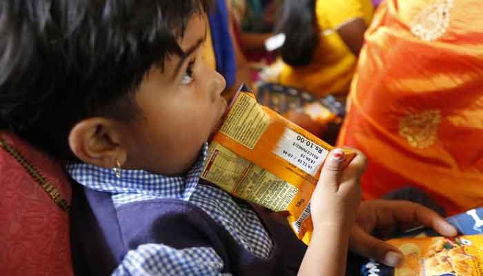 A child holds a pack of snack during a health awareness session in western Maharashtra state, India on March 28, 2019. — Reuters