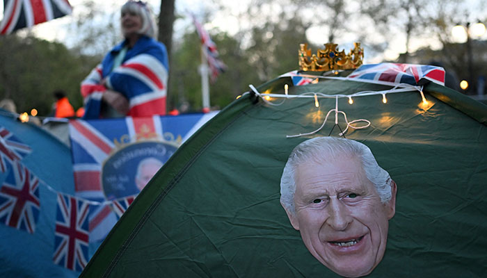 A crown sits on a tent, decorated with a portrait of Britain´s King Charles III on The Mall in central London, on May 4, 2023, ahead of the coronation weekend. — AFP