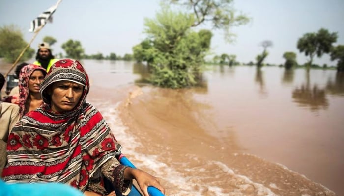 A flood victim sits on a boat while being evacuated from her flooded house following heavy rain in Jhang, on September 10, 2014. — Reuters