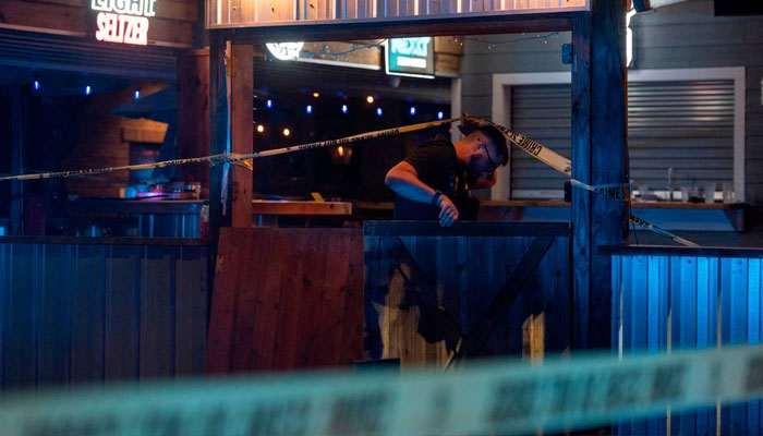 A law enforcement officer enters crime scene tape surrounding The Scratch Kitchen restaurant in Ocean Springs after a shooting left 1 dead and several injured on Friday, May 5, 2023. —Hannah Ruhoff Sun Herald