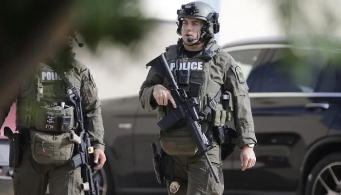 Law enforcement agents stand guard after the mass shooting at Allen Premium Outlets in Texas. — AFP