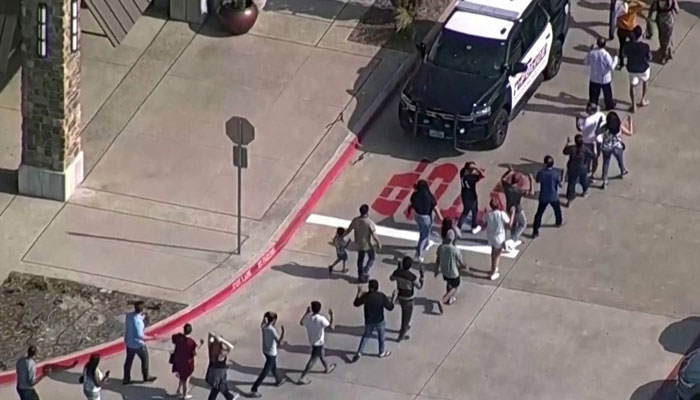 Shoppers leave with their hands up as law enforcement responds to a mass shooting in the Dallas areas Allen Premium Outlets, which authorities said left at least nine people dead in Allen, Texas, on Saturday in this image taken from video. REUTERS