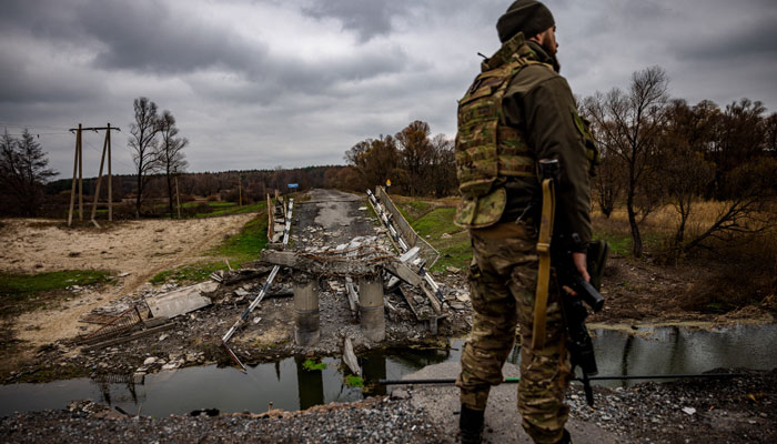 A Ukrainian soldier by a destroyed bridge near the Ukrainian border with Russia in the Kharkiv region. AFP/File