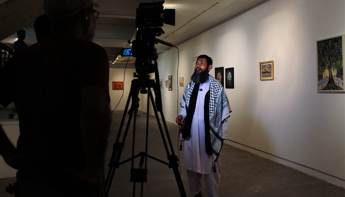 Ahmed gives an interview to a news outlet during his exhibition at IVS art gallery. — Photo by Hassaan Ahmed
