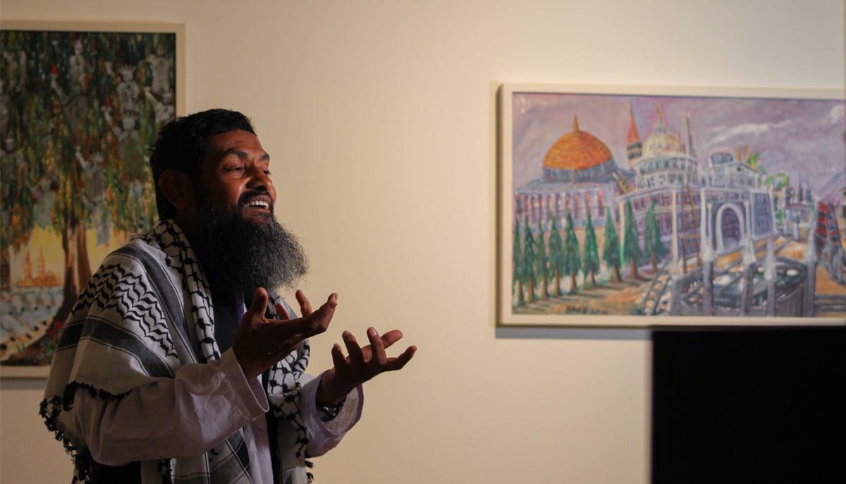 Ahmed Rabbani gestures while speaking with journalists during the exhibition of his artworks at IVS art gallery in Karachi. — Photo by Hassaan Ahmed