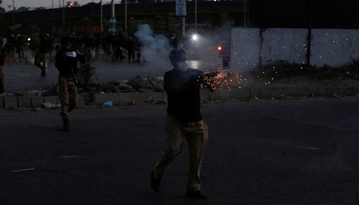A police officer fires tear gas to disperse the supporters of former prime minister Imran Khan, during a protest against his arrest, in Karachi, Pakistan May 9, 2023. — Reuters